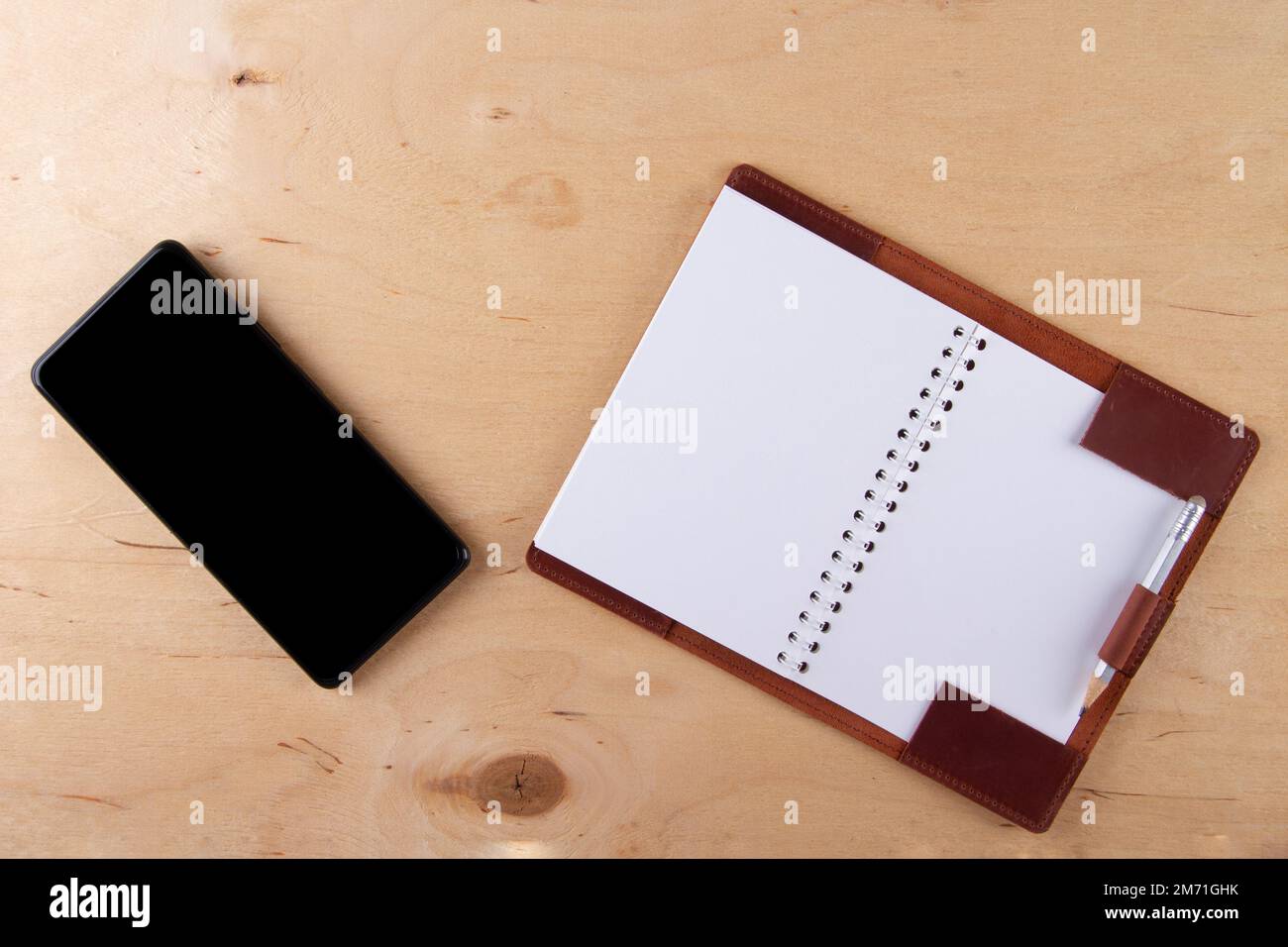 Digitalization concept. Paper notebook vs smartphone. Digital phone