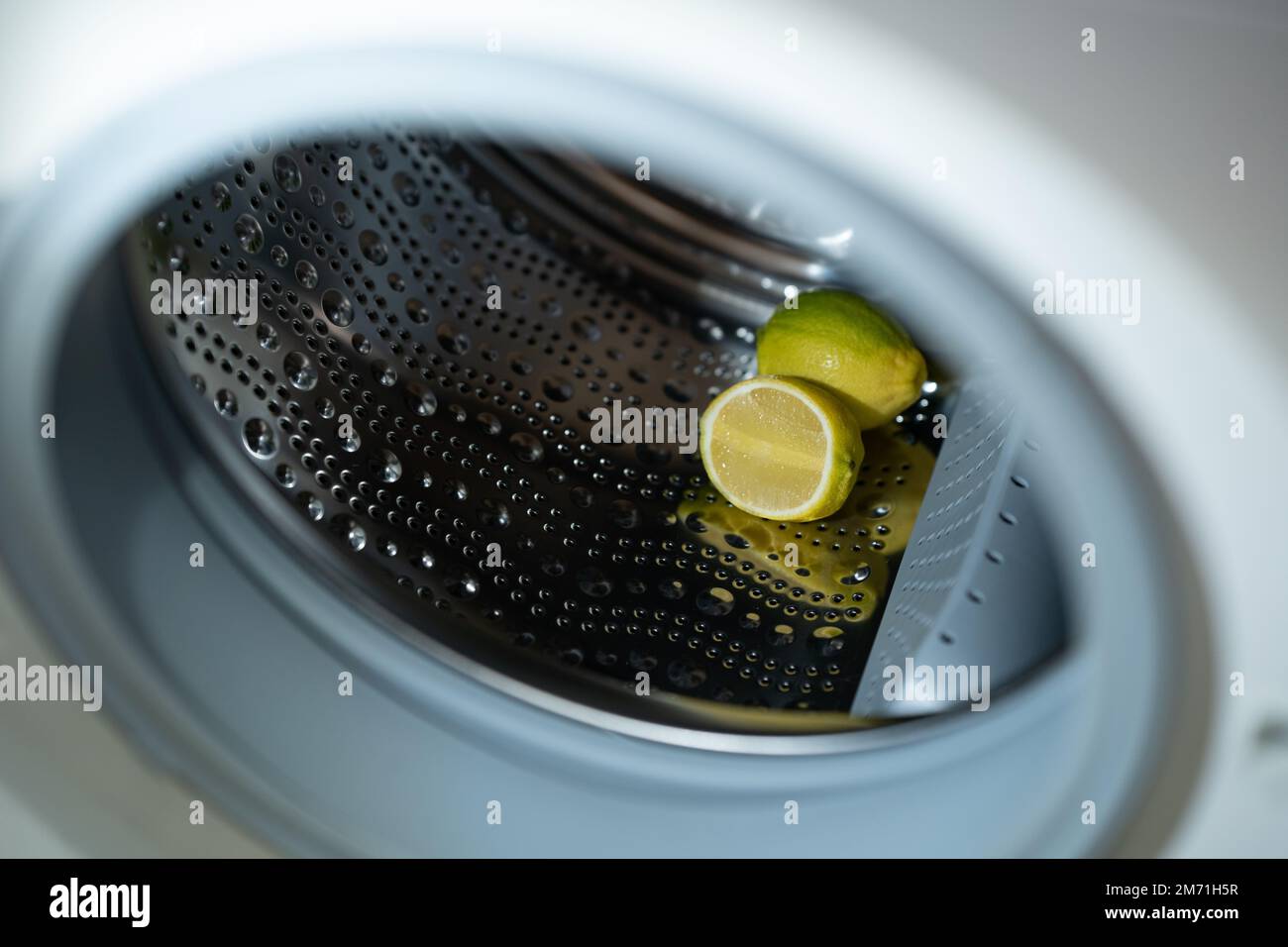 lemon inside washing machine. Half a lemon is placed on top of a whole