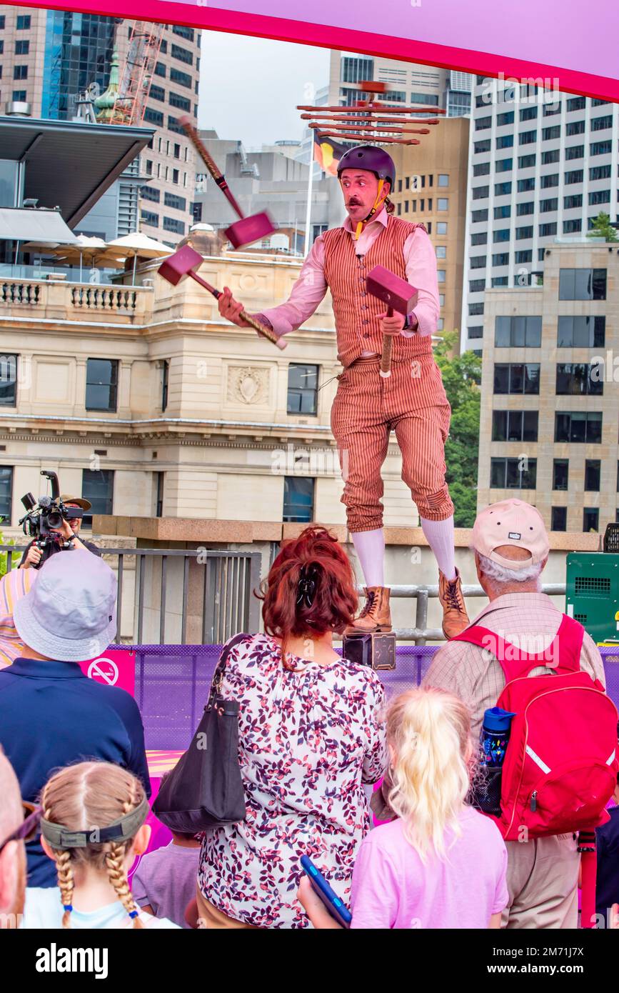 A circus performer acrobat Jesse, juggles wooden hammers (mallets) in his Juggling Mallet Show at Elevate Sydney in Jan 2023 on the Cahill Expressway Stock Photo