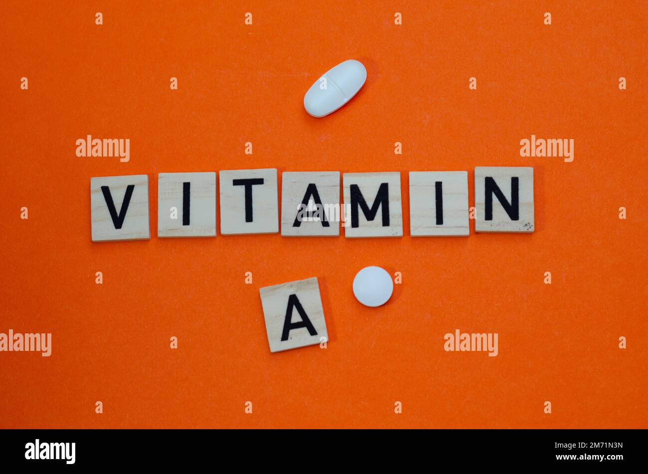 Word vitamin c in wooden letters on orange background. Concept of