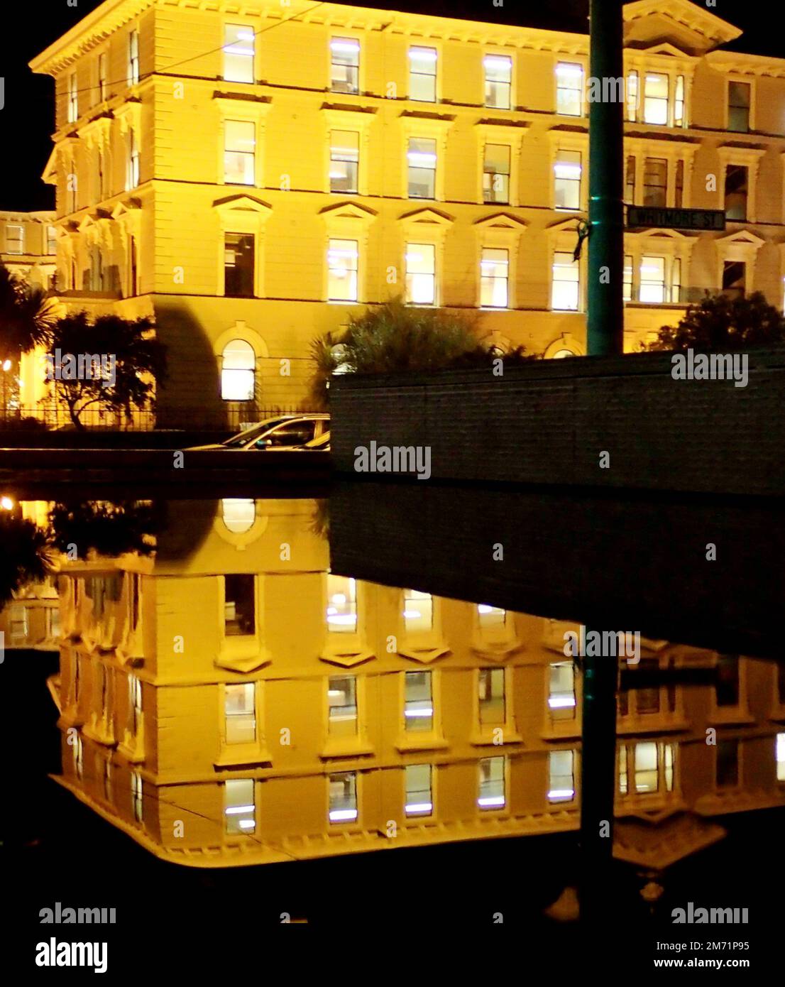 Wellington's old government building. A large timber building, reflected in the pool frontage of the Supreme Court across the road) Stock Photo