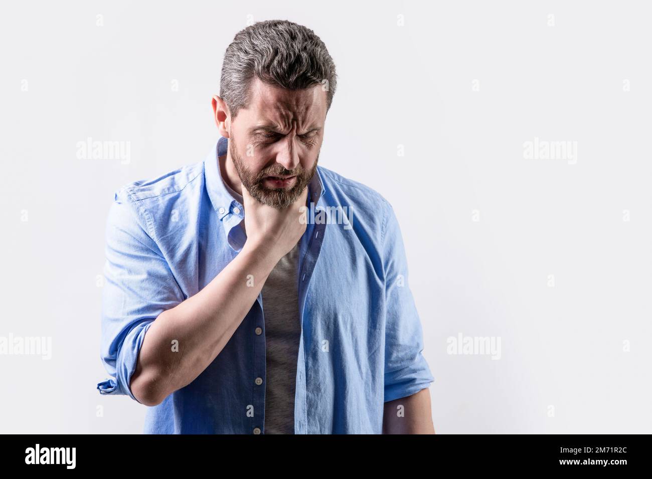 sore of mature man with soreness pain isolated on grey with copy space. man with soreness Stock Photo