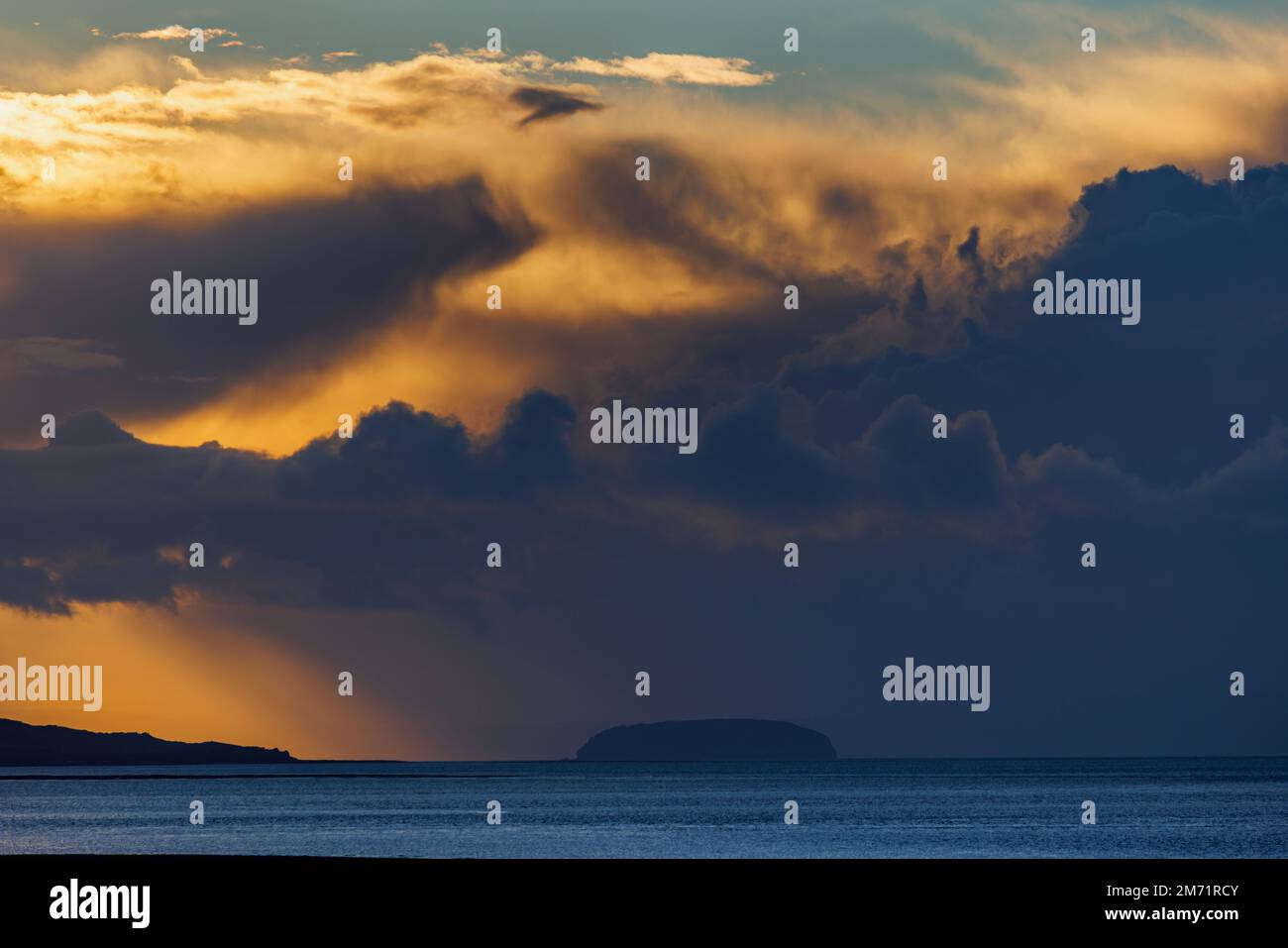 The setting sun lighting up the cloud cover Stock Photo