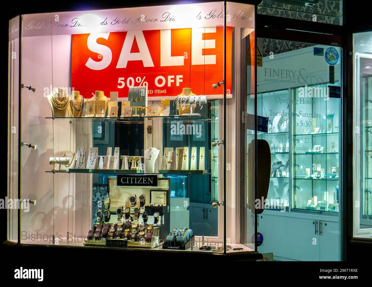 Large sale sign in a jewellery shop window lit at night in Saffron