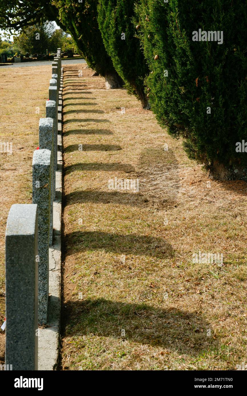 Hamilton New Zealand April 25 2010; Headstones in row cast shadows