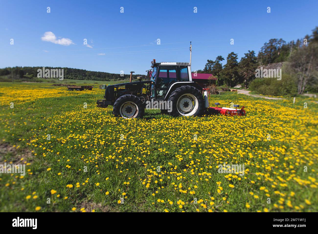Tractor with a disc harrow system on the cultivated farm field, process