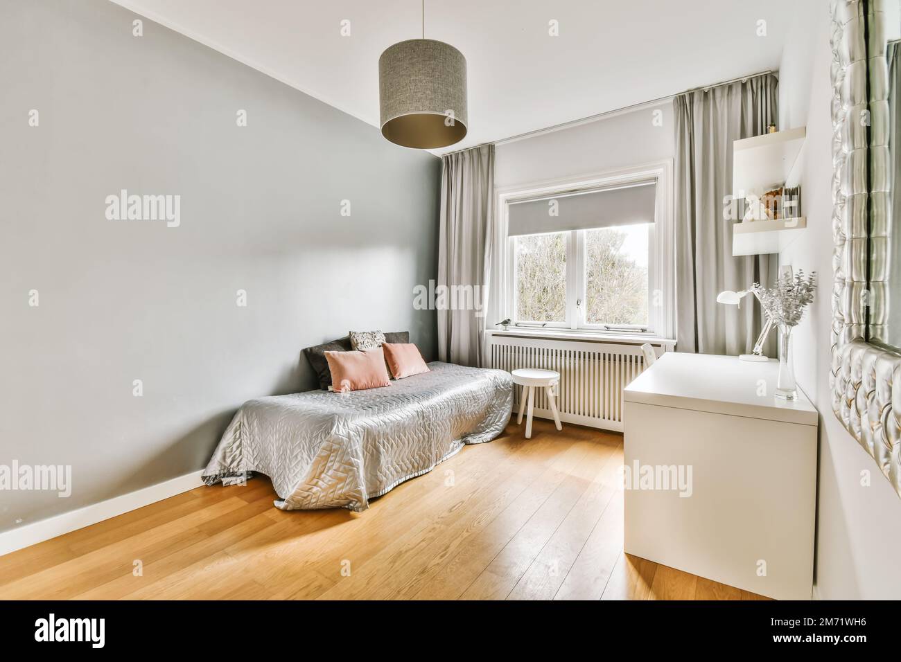 a bedroom with wood flooring and light gray walls, white trim around