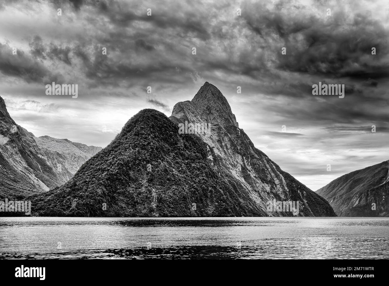 Dramatic black-white Mitre peak rock mountain in Milford Sound fiordland of New Zealand - scenic nature landscape view from cruise boat. Stock Photo