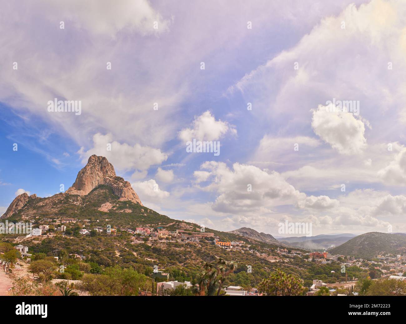Beautiful panorama of the Peña del Bernal in a sunny morning with clouds and blue sky, no people Stock Photo