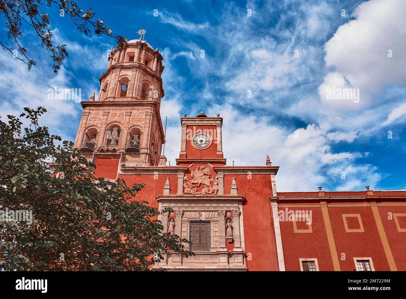 Santiago de Queretaro, Queretaro, Mexico, 09 07 22, Main entrance next to the tower and bell of the Temple of San Francisco de Asís with a blue sky an Stock Photo