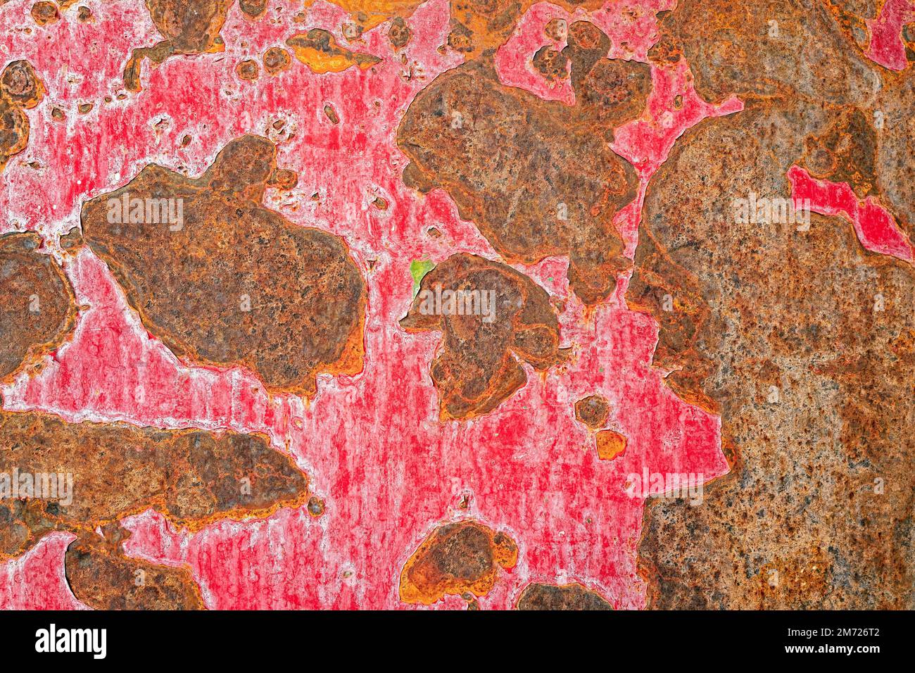 The red paint peeling from a rusty metal surface Stock Photo