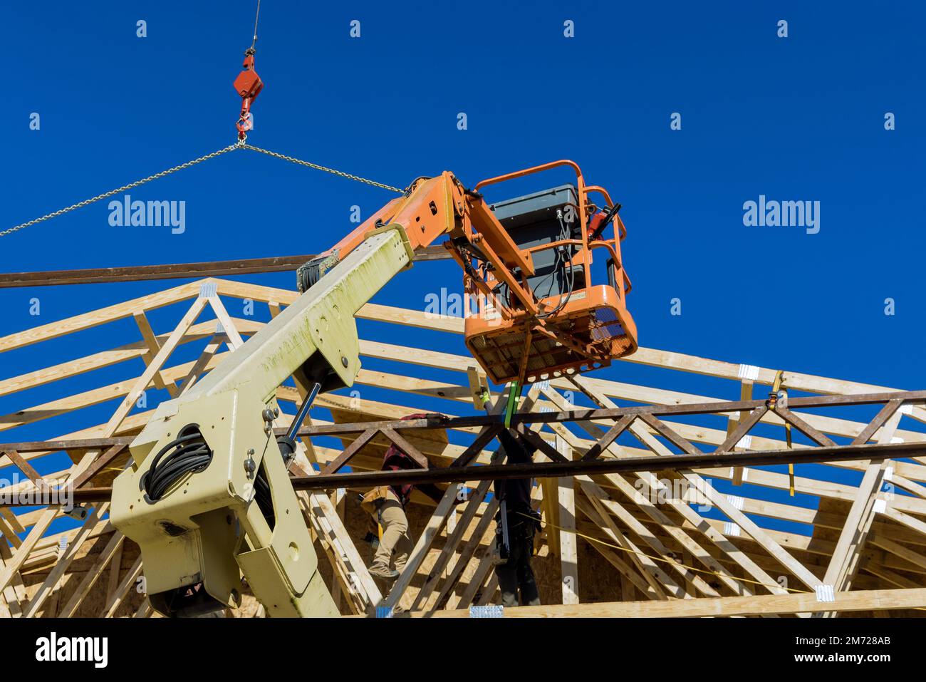 During construction of rafters an unfinished wooden house crane holds