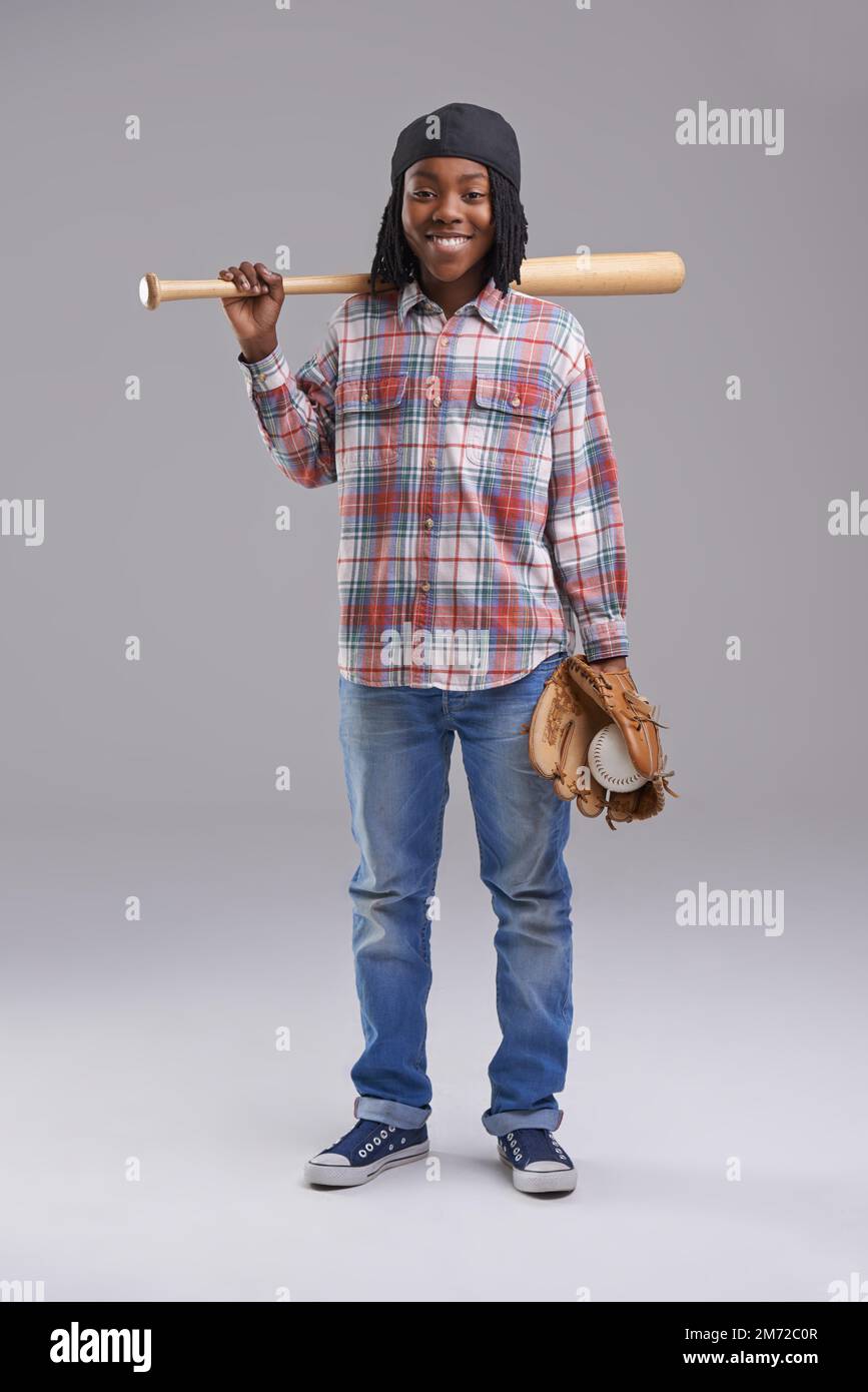 Ready to bat away. Studio shot of a young boy with baseball gear. Stock Photo