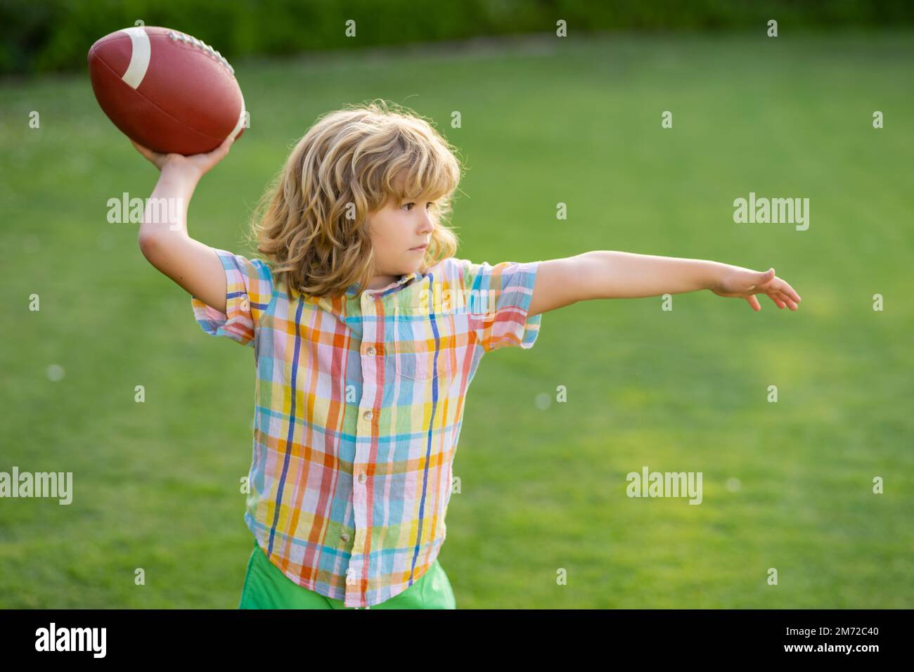 Portrait of child with rugby ball. Kid with american football, rugby
