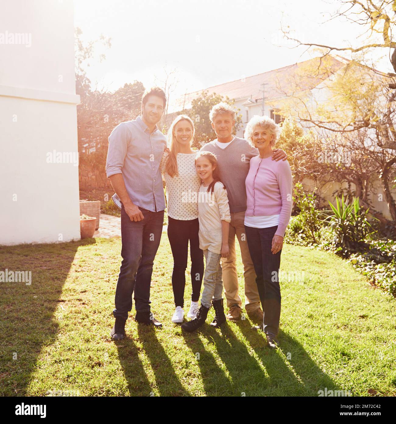 They stick together like glue. A full length portrait of a happy multi-generation family standing outdoors. Stock Photo