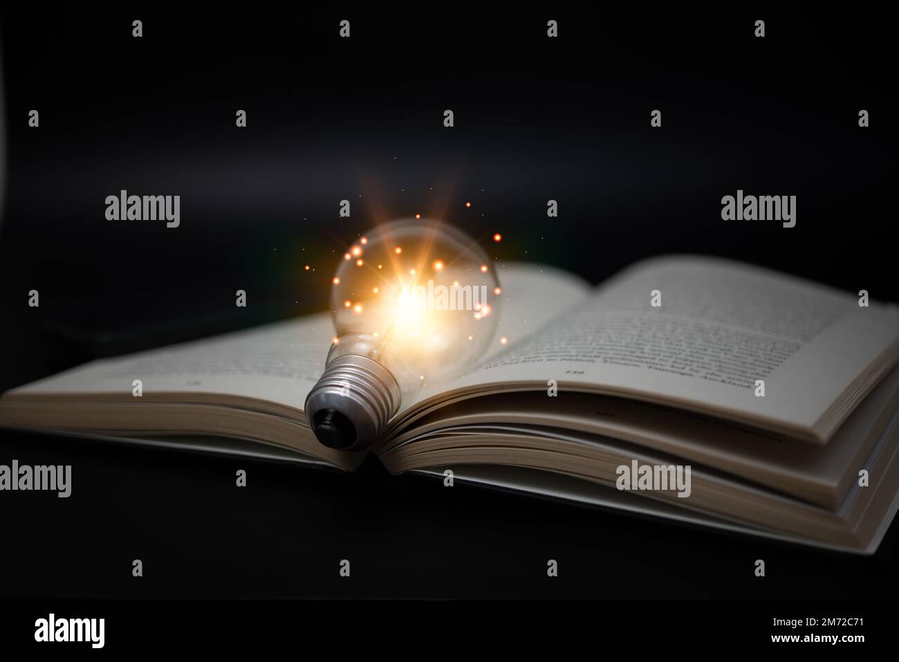 Education knowledge and business studying success idea or solution concept, Bright lamp or glowing light bulb and book on table background. Stock Photo
