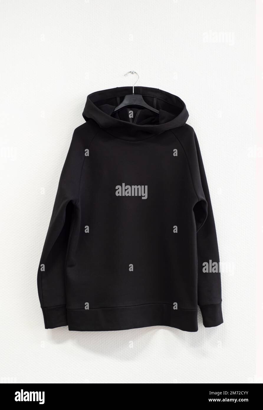 Stylish black sweater with a hood on a white background, front view