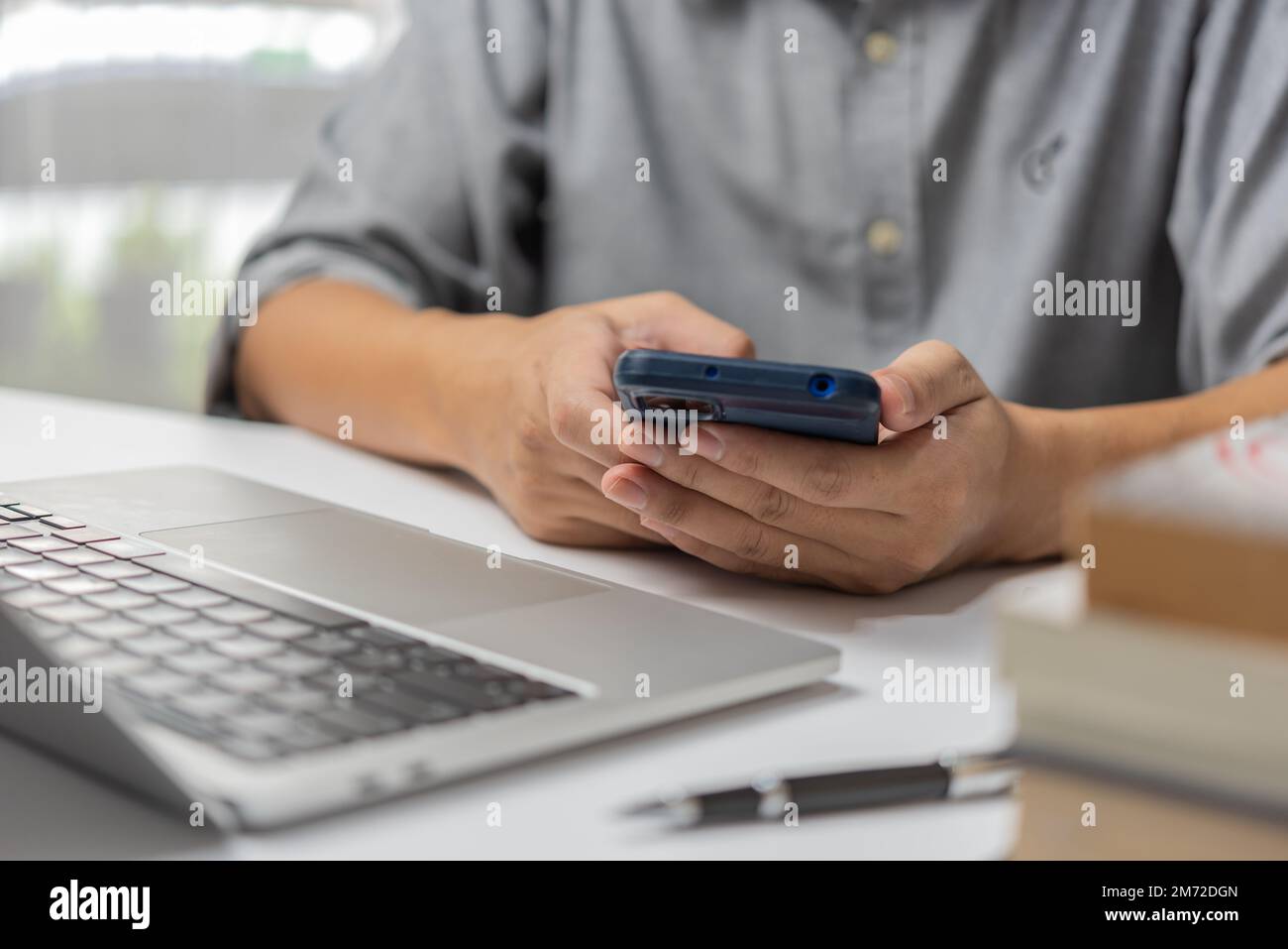 man using mobile smartphone in his hands. Freelancer at work.online' Stock Photo
