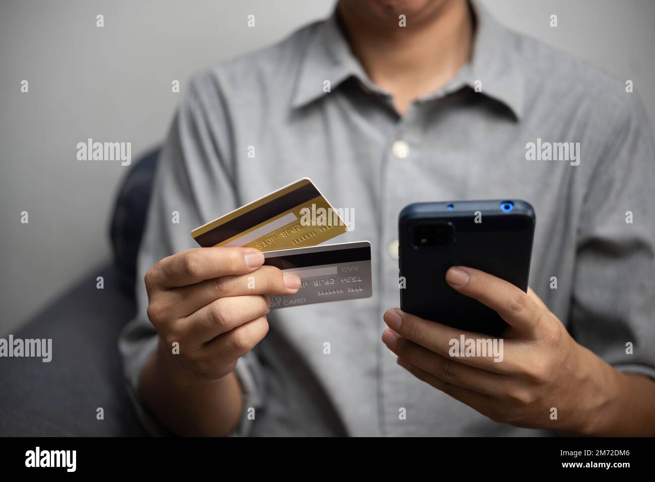 Man using smartphone for online banking or shopping and payment via credit card. man paying and shopping with mobile phone application e commerce wall Stock Photo
