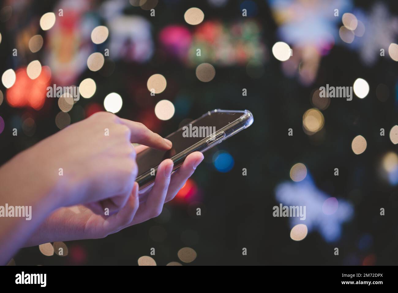 male hands using smartphone at night on city with background bokeh. Stock Photo