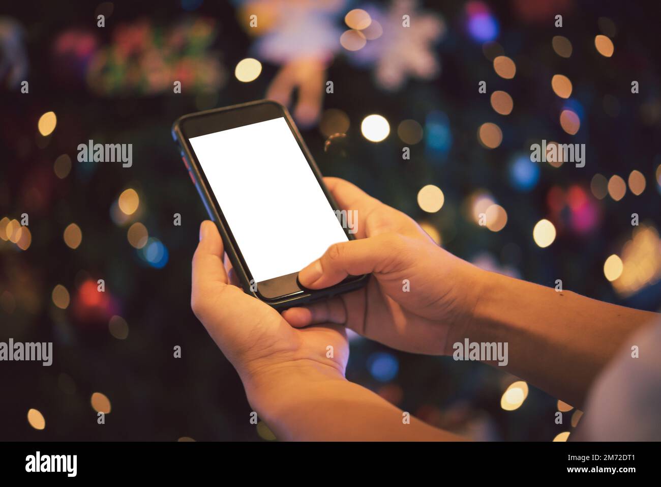 male hands using smartphone at night on city with background bokeh.Phone blank mock up white screen. Stock Photo