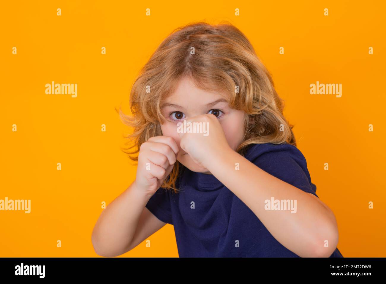 Angry child on studio isolated background. Upset kid boy with mad expression. Boy fight, battle. Stock Photo