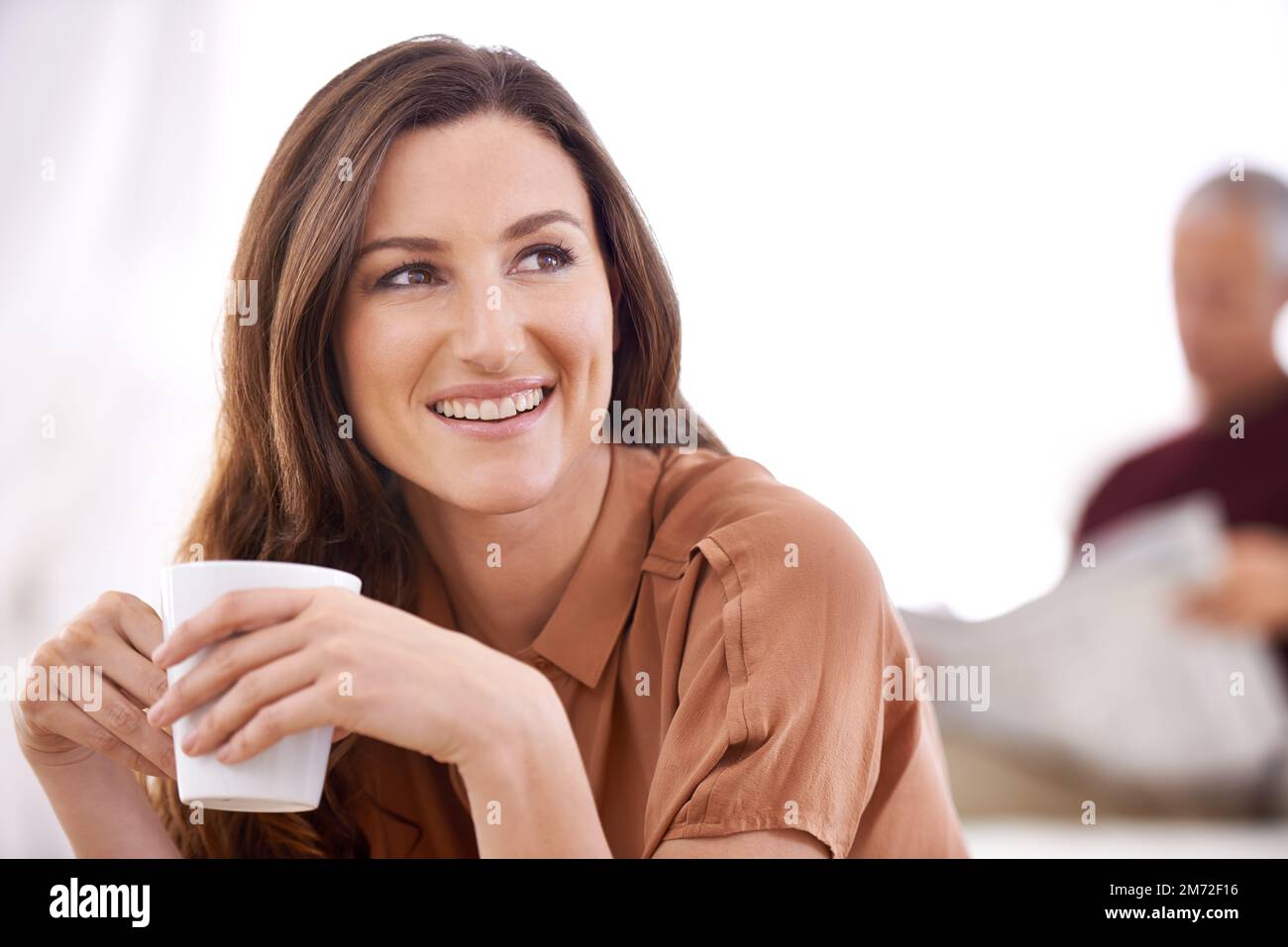 Morning rituals dont have to be boring. a happy young woman drinking a beverage while her husband reads the newspaper. Stock Photo