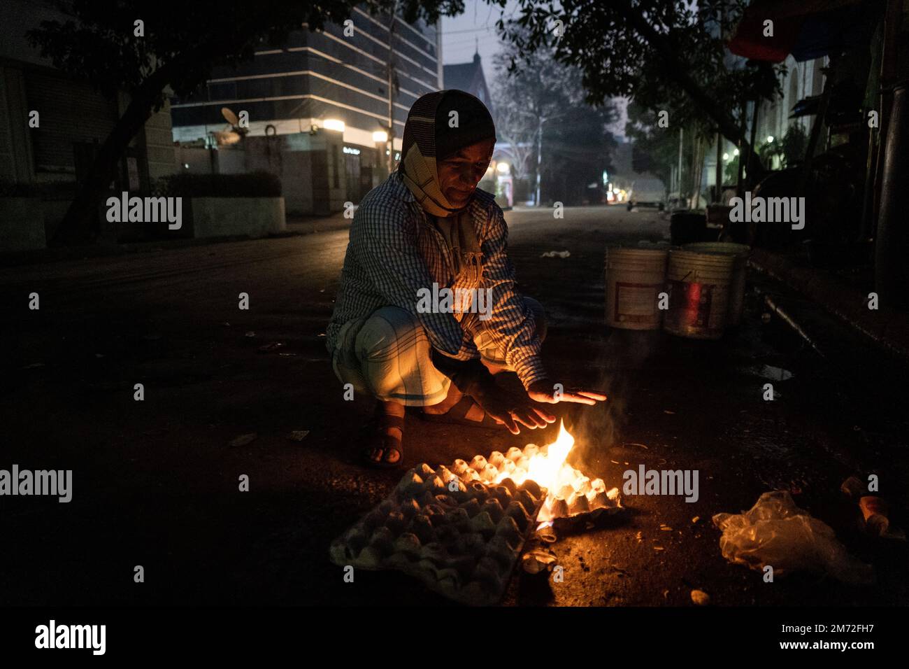 Kolkata, West Bengal, India. 7th Jan 2023. A street vendor sets egg crates on fire to keep warm. Credit: Matt Hunt / Neato/Alamy Live News Stock Photo