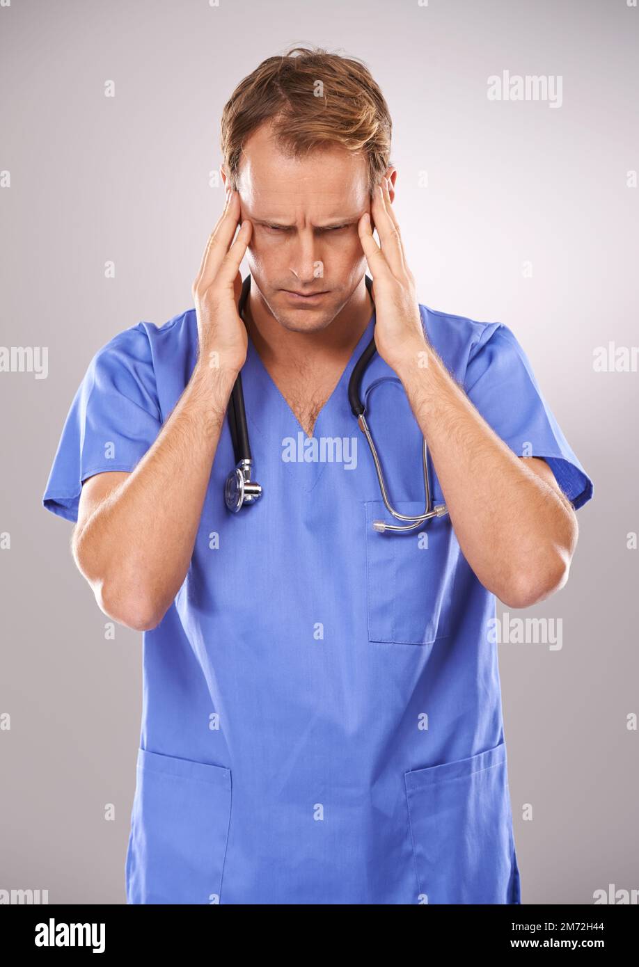Too much surgery stress. Studio shot of a doctor holding his head in ...