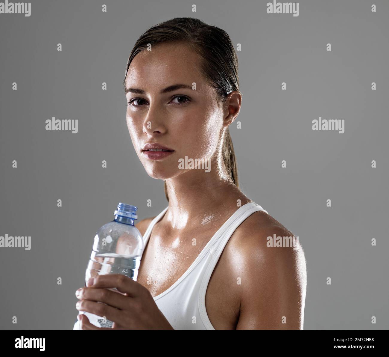 Got to keep hydrated. an attractive young woman taking a break from her workout to drink some water. Stock Photo