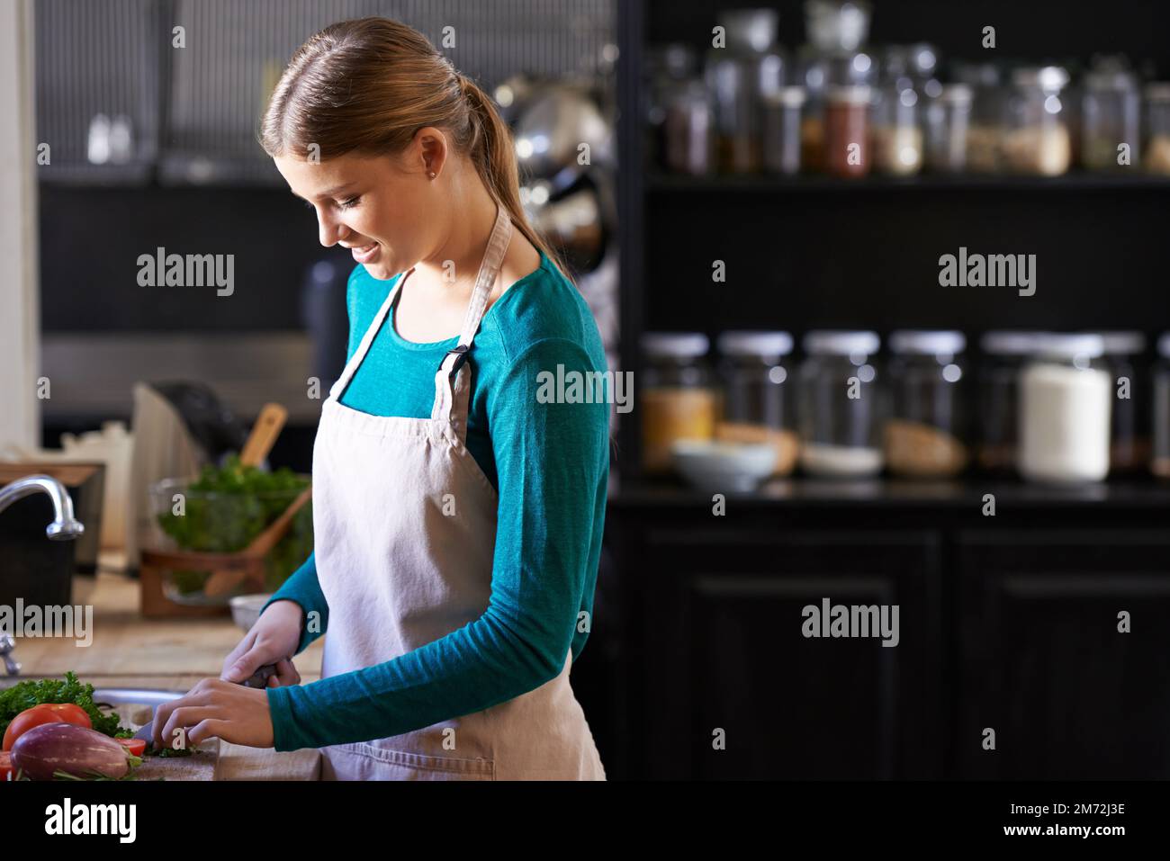 Slice and dice. an attractive young woman chopping vegetables in a kitchen  Stock Photo - Alamy