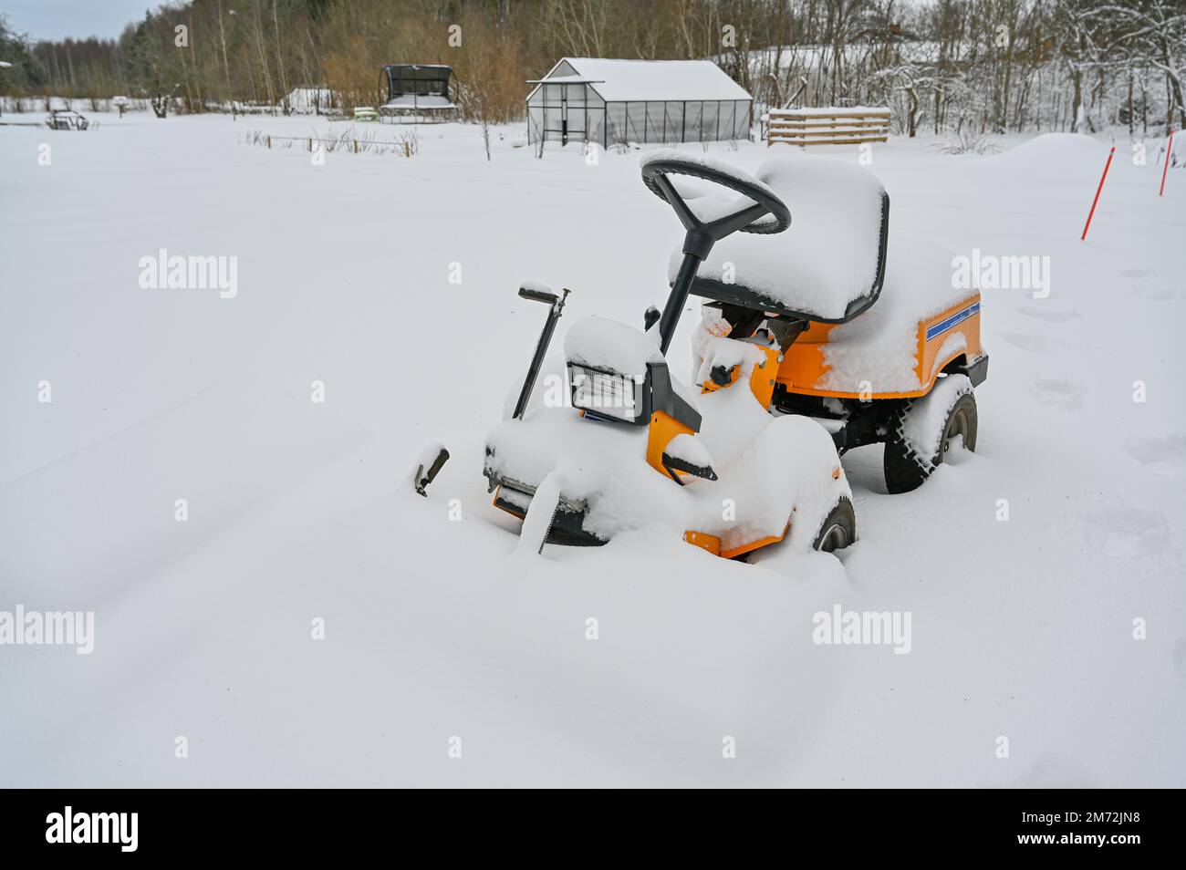 yellow riding lawn mower covered in snow Stock Photo - Alamy