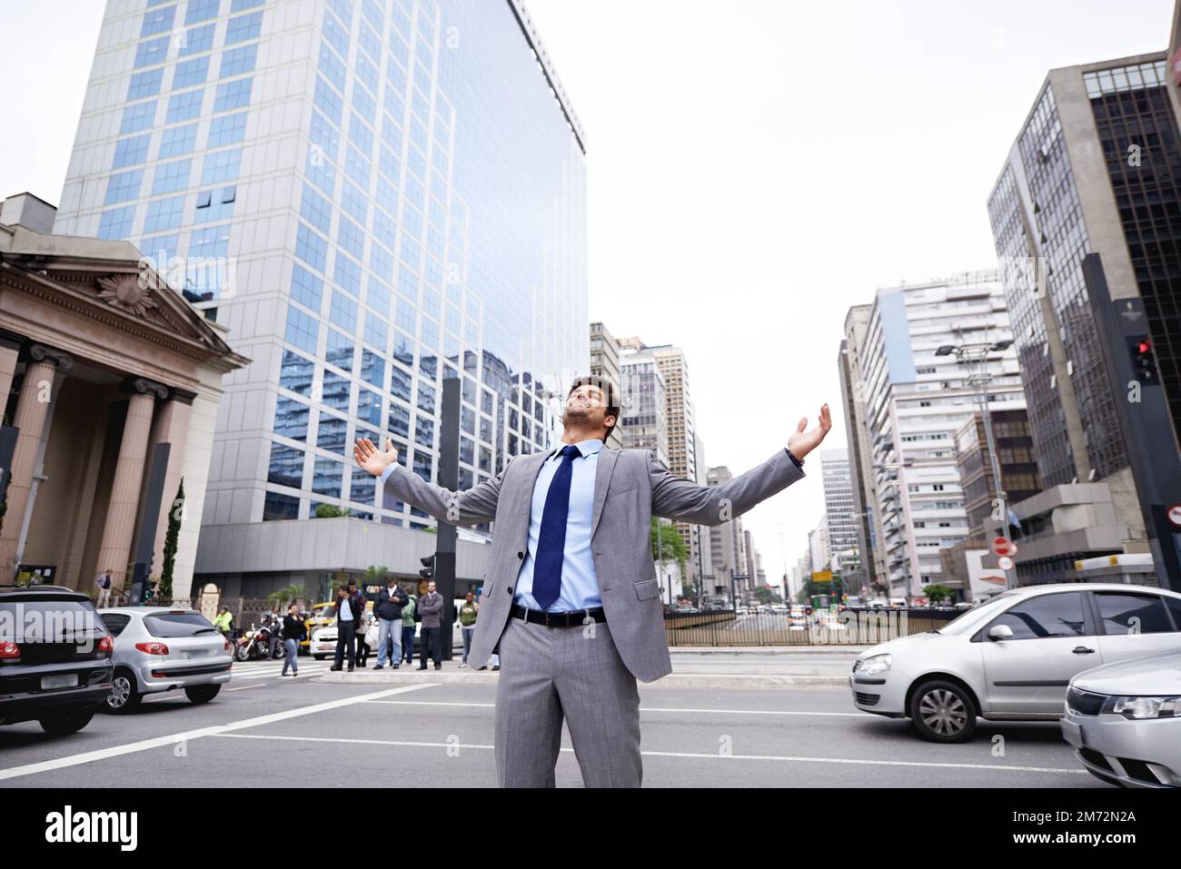 I love the city. A contented young businessman standing in the city with his eyes closed and his arms raised. Stock Photo