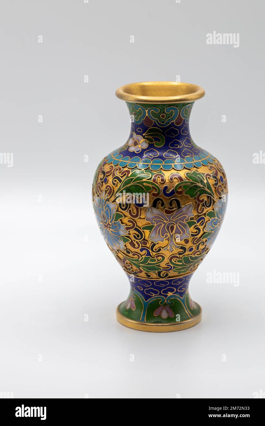 Macro view of a small antique cloisonne vase with multicolored enamel on a gold base, showing wear from age Stock Photo