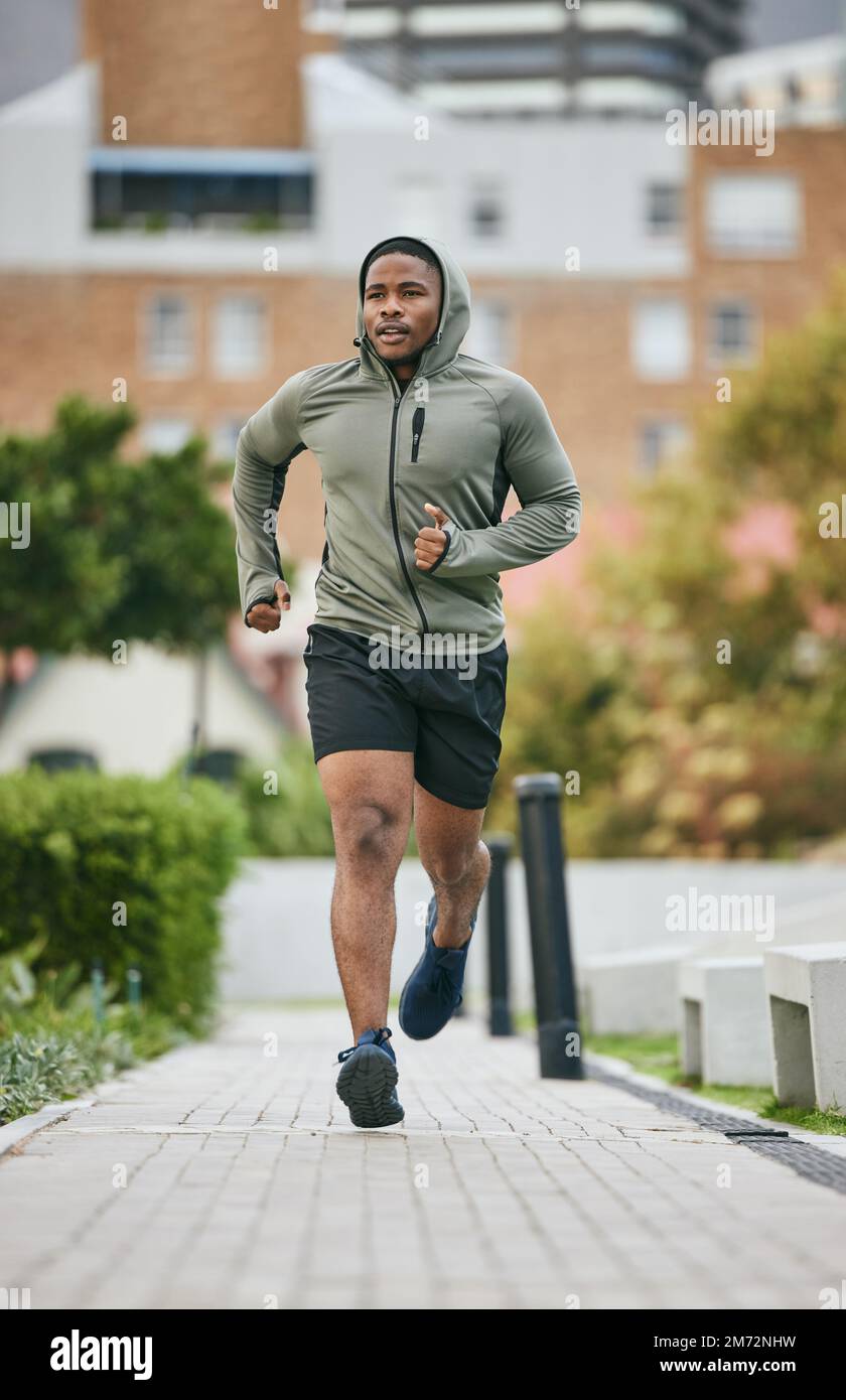 Fitness, exercise and black man running in city in winter for health, wellness and strength. Sports, thinking and male runner exercising, cardio jog Stock Photo