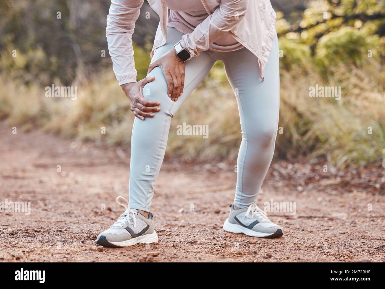 Sports, knee pain and woman in park after running, exercise and marathon training for healthy lifestyle. Wellness, fitness and hands of female athlete Stock Photo