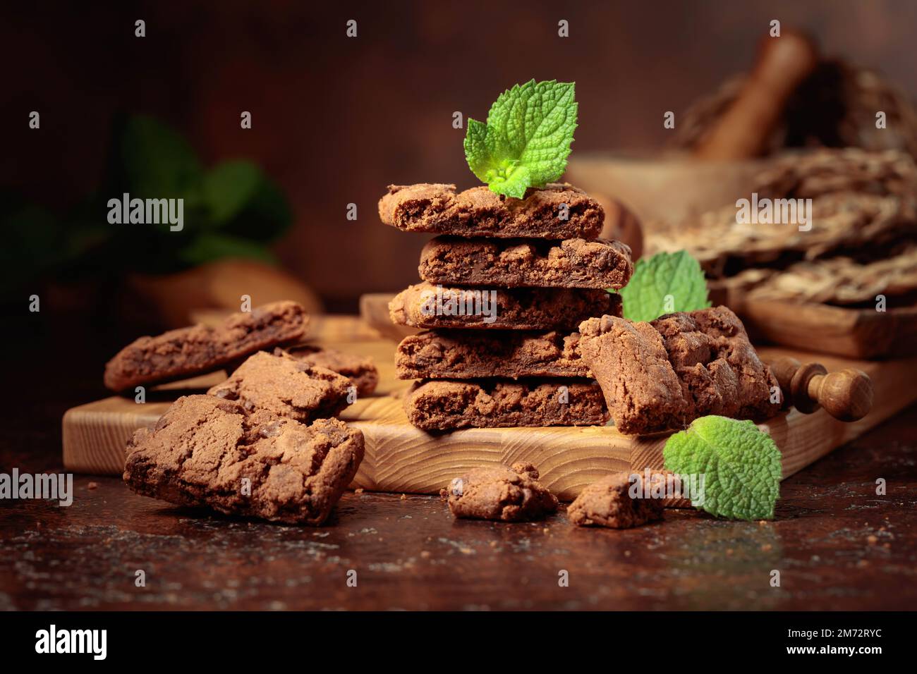 Pieces of fresh brownie with mint on an old table with kitchen utensils