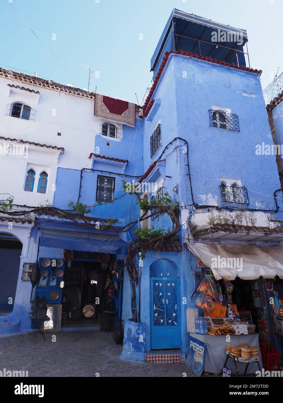 CHEFCHAOUEN, MOROCCO on APRIL 2019: Arabic frontage in african city, clear blue sky in warm sunny spring day - vertical Stock Photo