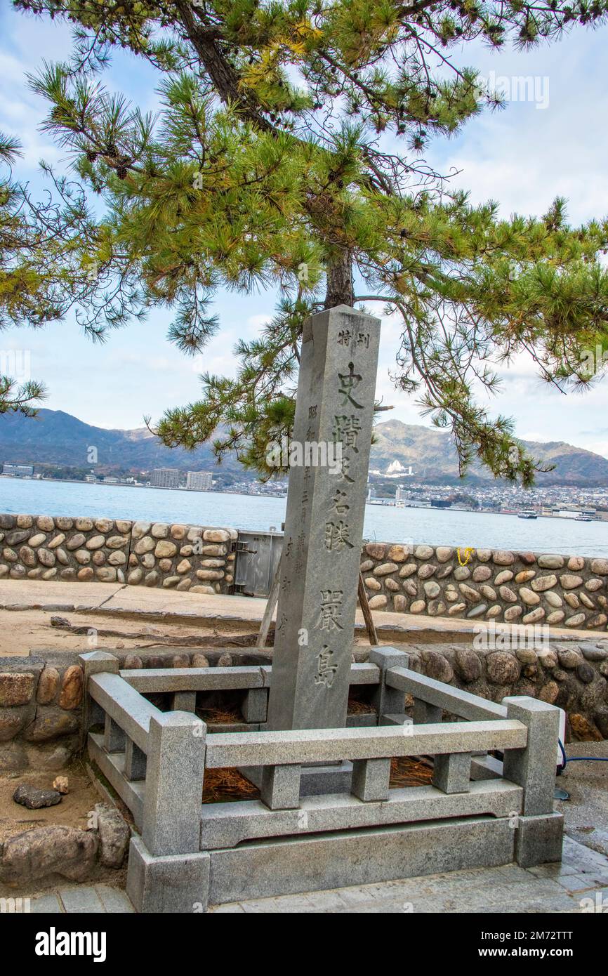 The stone pillar with name of 'scenic spot Itsukushima'. Background is the city view of Miyajima guchi Japan. Stock Photo