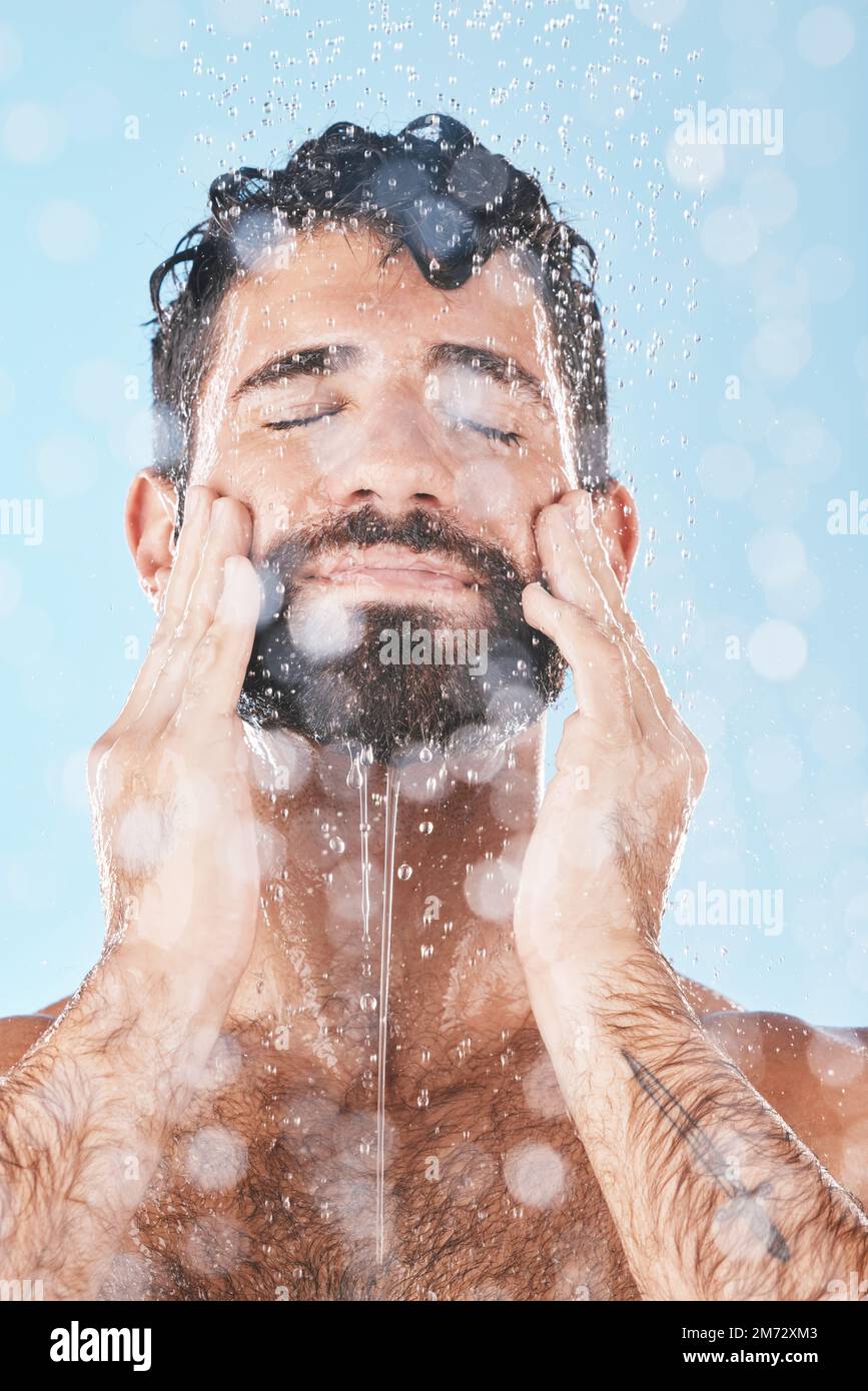 Face, skincare shower and water splash of man in studio isolated on a ...
