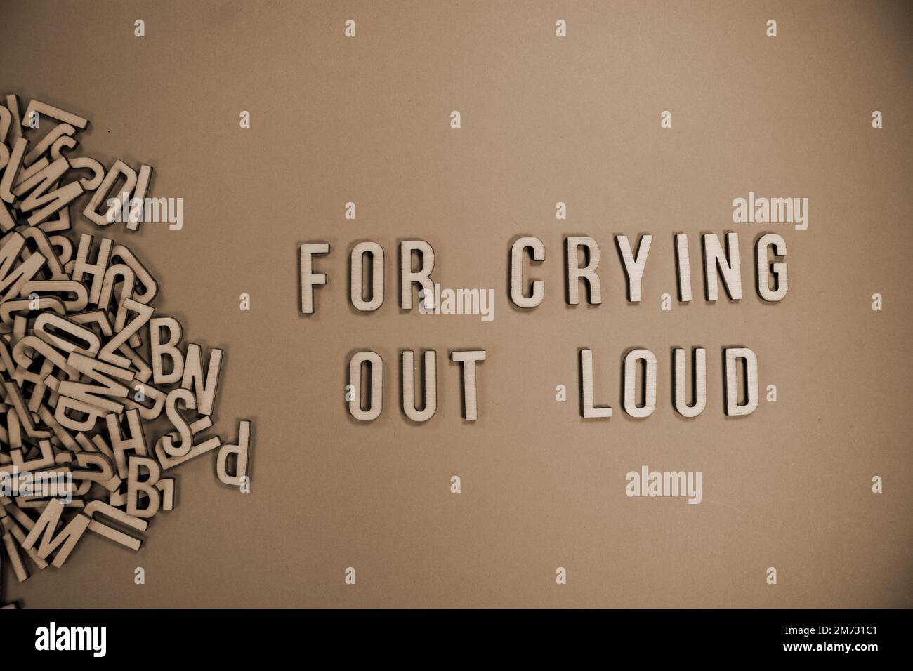 FOR CRYING OUT LOUD in wooden English language capital letters spilling from a pile of letters