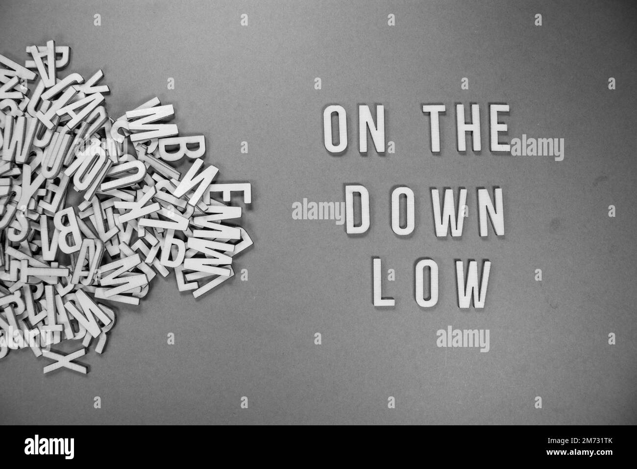 ON THE DOWN LOW in wooden English words language capital letters