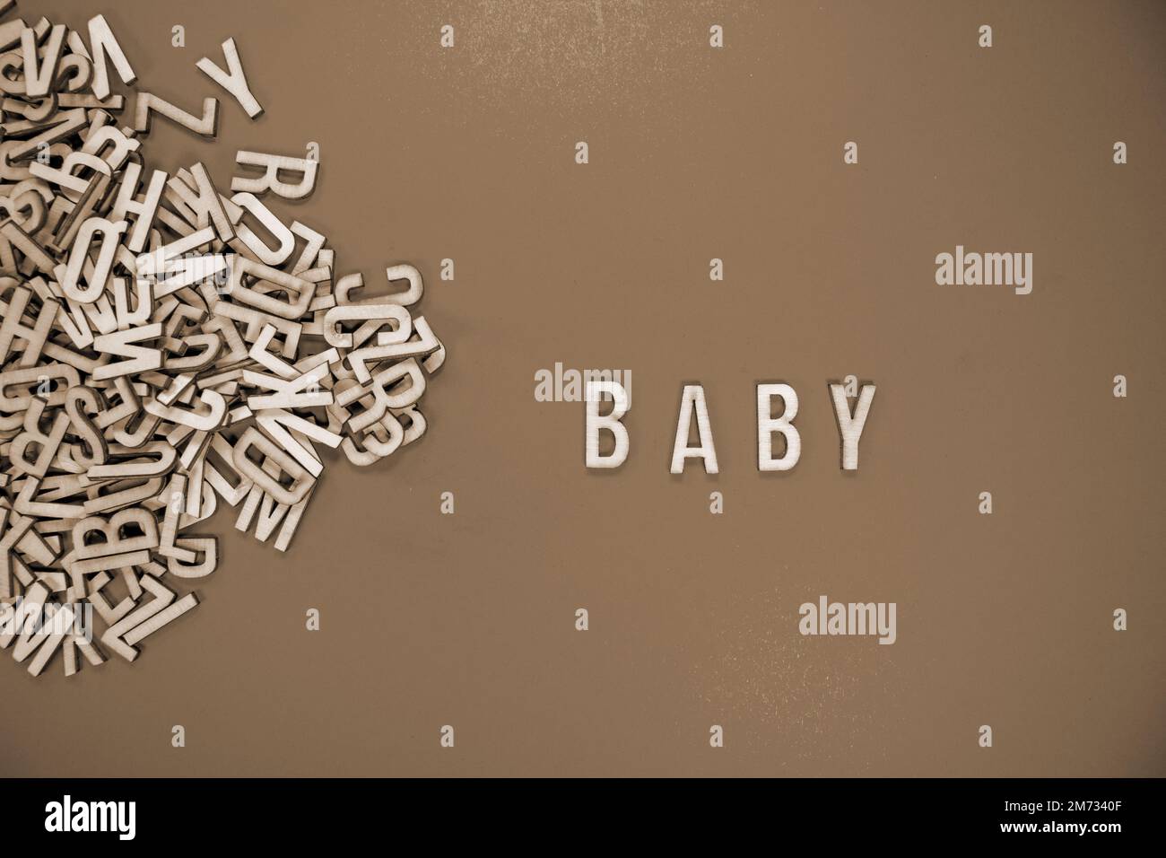 BABY in wooden English language capital letters spilling from a pile of ...