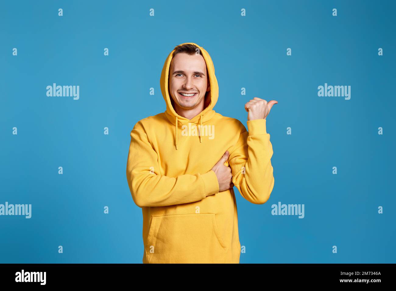 Cheerful handsome man pointing at copy space Stock Photo