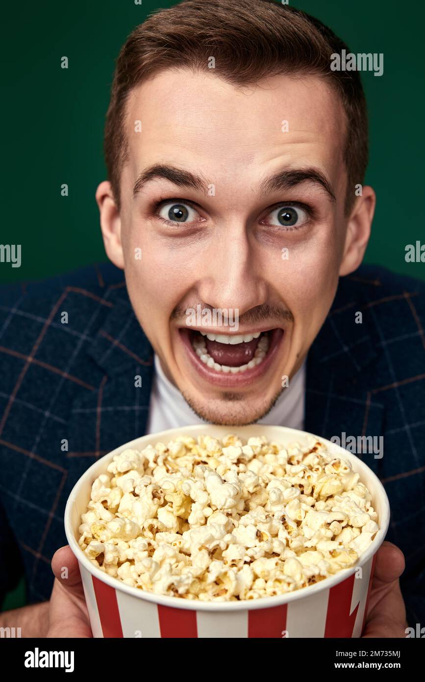 Young caucasian man in 3d glasses eating popcorn Stock Photo