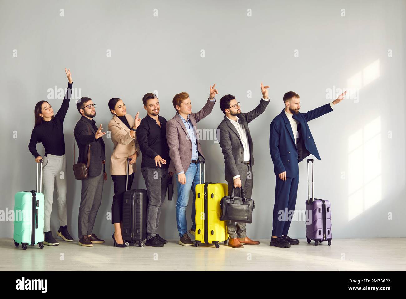 Group of people standing at the airport, waving hands, saying goodbye to their friends Stock Photo