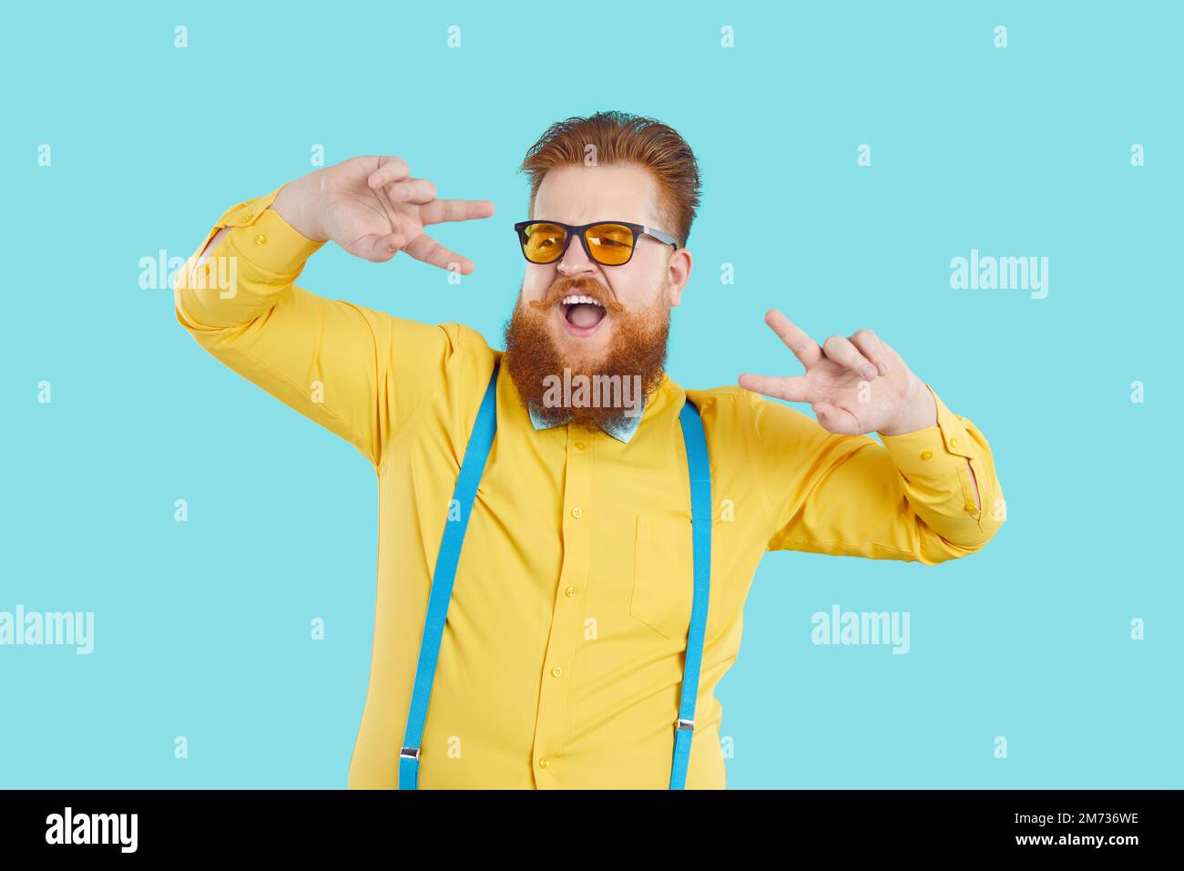 Funny bearded Caucasian man performs dance working as presenter or showman stands in studio Stock Photo