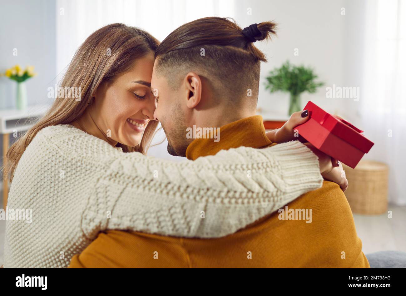 Happy couple in love celebrating Valentine's Day, hugging, kissing, giving each other presents Stock Photo