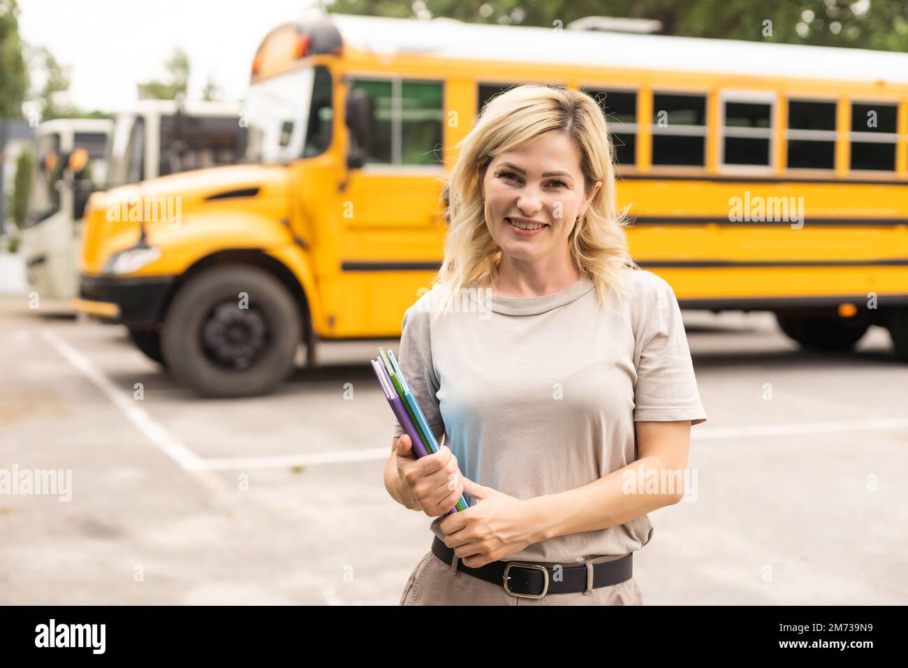 Teacher of elementary school near the school bus Stock Photo - Alamy