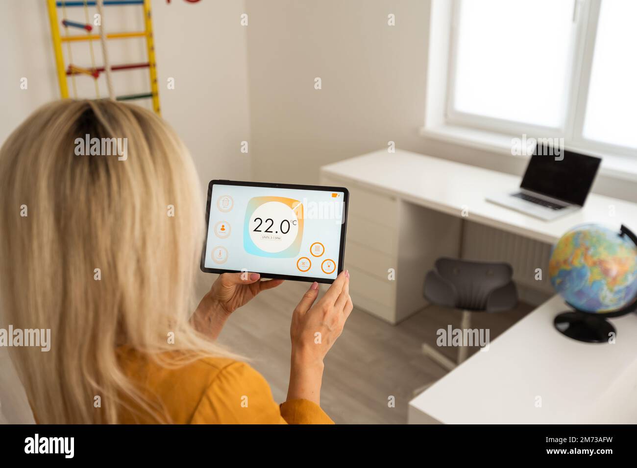 Woman using smart wall home control system. Stock Photo
